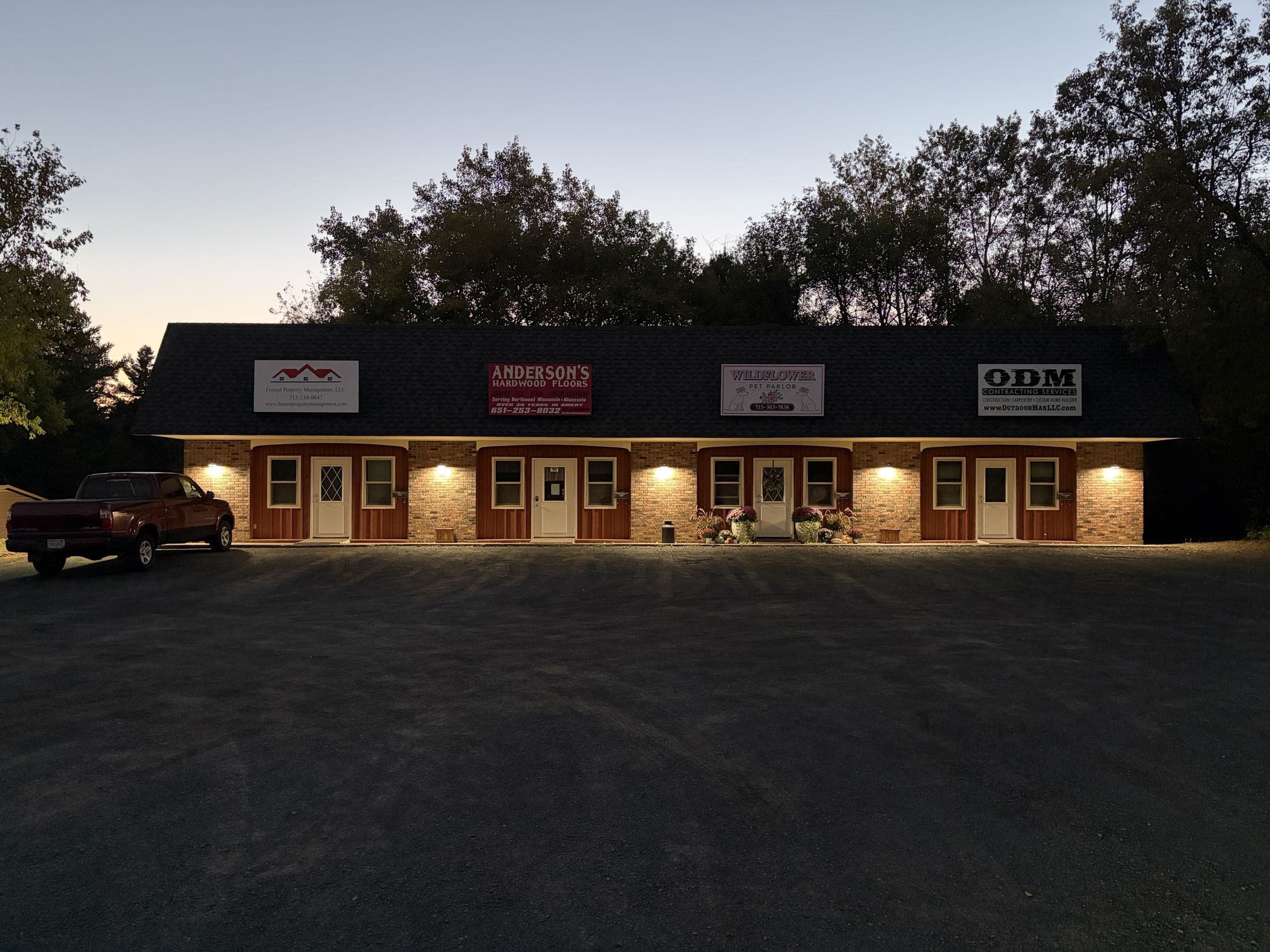 543 State Hwy 46 at dusk with new exterior lighting across all four storefronts