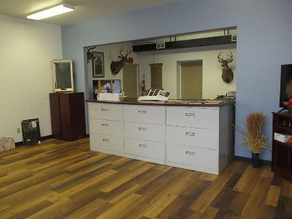 Suite D interior — open front room with wood-look flooring and a built-in counter